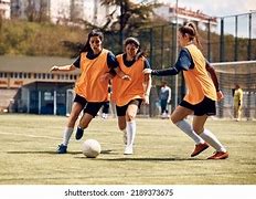 Female footballers in action at a training session.