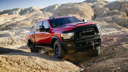 A powerful Ram heavy-duty pickup truck showcasing its towing capacity and rugged off-road capabilities in a scenic outdoor setting.