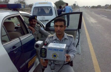 National Highways and Motorway Police (NHMP) officers monitoring traffic speed on a major motorway in Pakistan