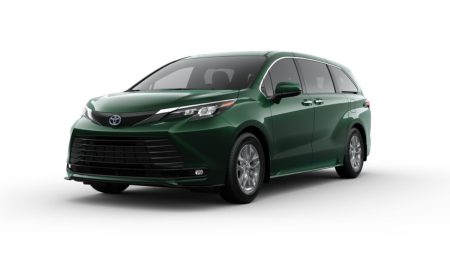 Red 2025 Toyota Sienna hybrid minivan parked with a scenic background