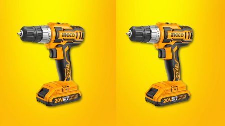 Cordless charging drill machine with battery and drill bits on a wooden surface