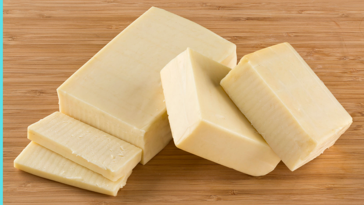 Variety of cheese blocks and slices with price tags in a Pakistani grocery store in 2025