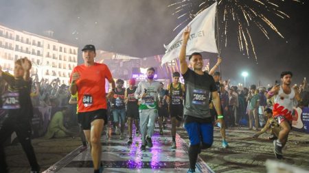 Participants running in Islamabad Night Run 2025 under lights with crowd cheering