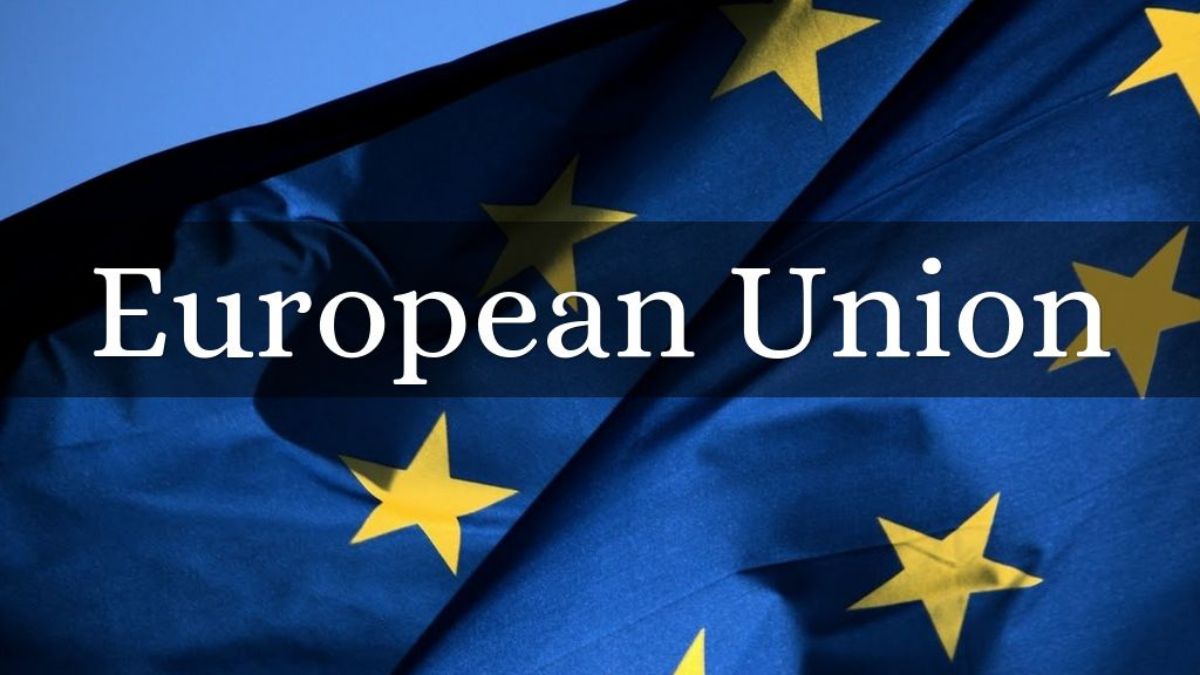 European Union flag waving in front of the European Parliament building with 2025 member countries listed