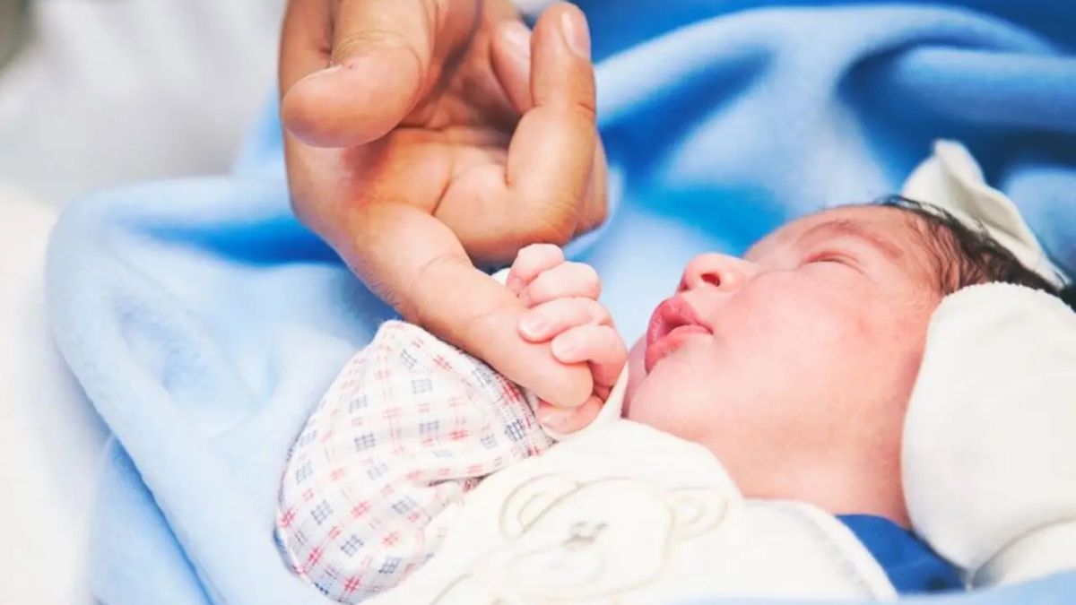 Happy family embracing their adopted baby in Lahore