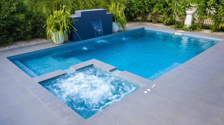 In-ground swimming pool with clear water, patio, and outdoor seating