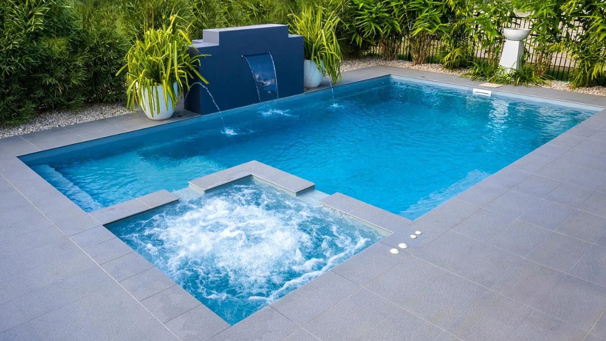 In-ground swimming pool with clear water, patio, and outdoor seating