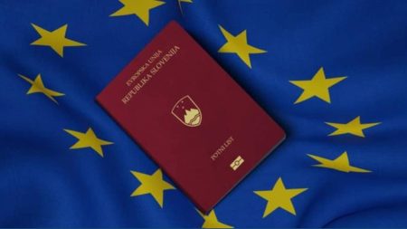 A remote worker using a laptop in Slovenia with scenic mountains in the background, representing the 2025 digital nomad visa opportunity