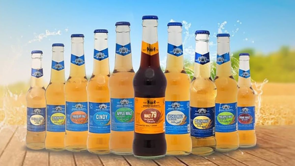 Glass of chilled lemon malt drink with bottle on table