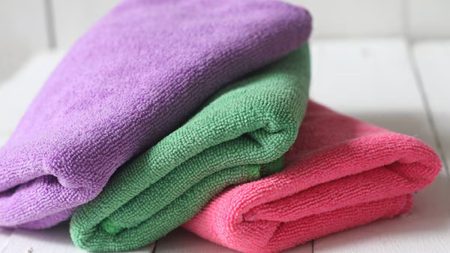 Soft folded microfiber towels in various colors for cleaning and personal care