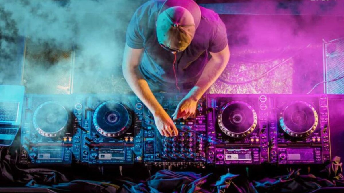 DJ mixing tracks on a controller with headphones in a studio setting