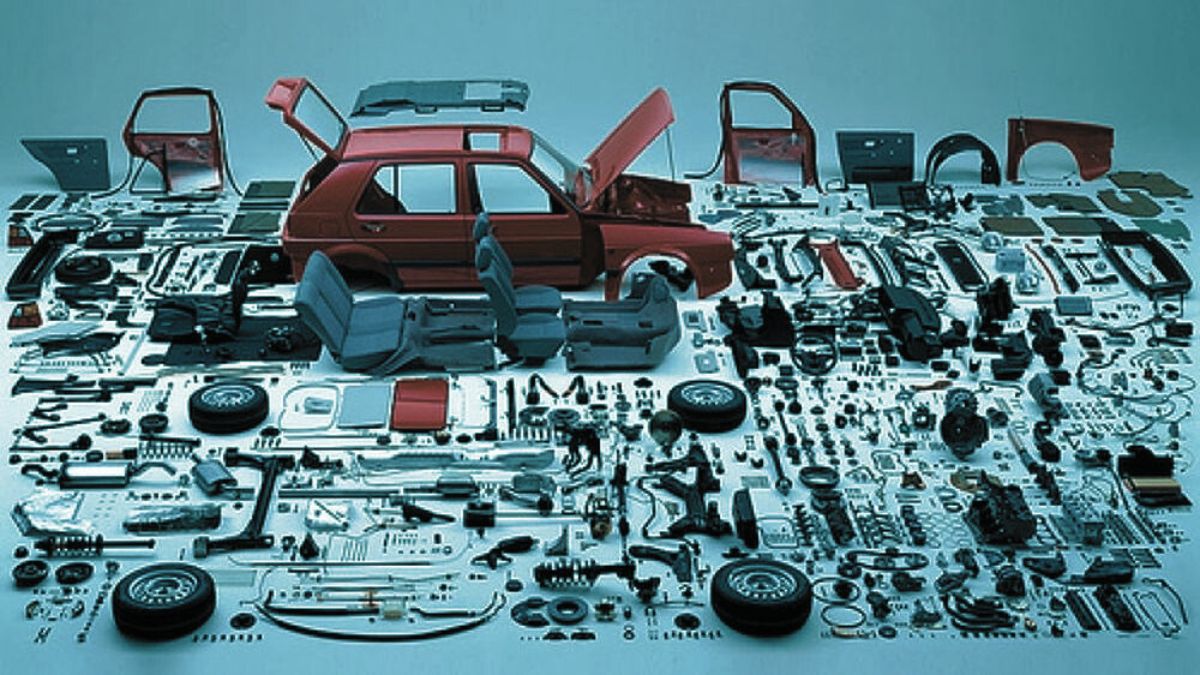 Mechanic checking OEM car part numbers for compatibility in Pakistan.